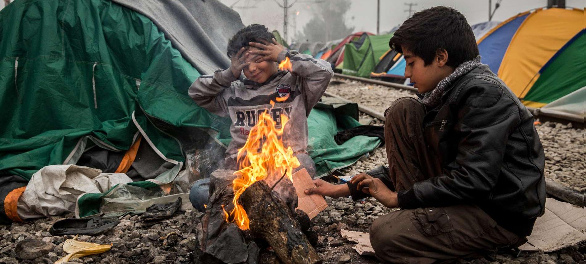Zwei Kinder wärmen sich im griechischen Flüchtlingscamp Idomeni an einem offenen Feuer. Foto: Olmo Calvo